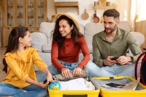 Family packing suitcase for vacation, laughing together